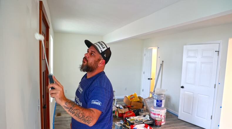 Steven Young, from Habitat for Humanity, paints the walls of a house that they're renovating on Bell Avenue in Springfield Wednesday, Dec. 14, 2022. BILL LACKEY/STAFF