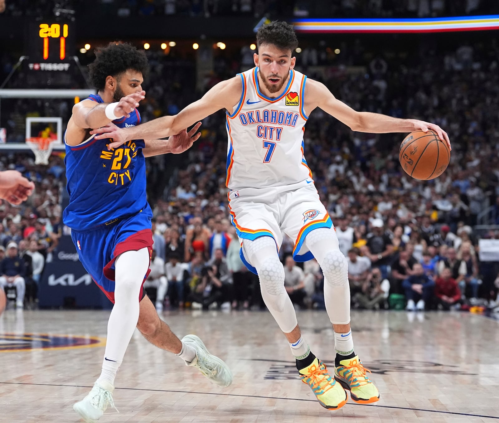 Oklahoma City Thunder forward Chet Holmgren, right, drives past Denver Nuggets guard Jamal Murray in overtime of Game 3 in the Western Conference semifinals of the NBA basketball playoffs, Friday, May 9, 2025, in Denver. (AP Photo/David Zalubowski)