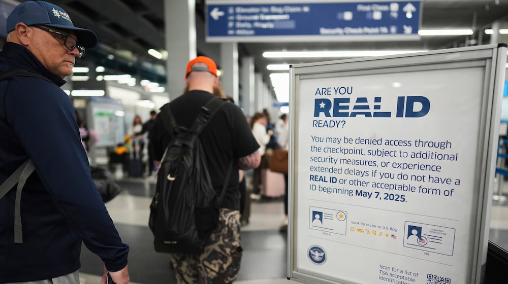 FILE - Travelers walk past a Real ID sign posted inside terminal 3 at O'Hare International Airport in Chicago, Friday, May 23, 2025. (AP Photo/Nam Y. Huh, File)