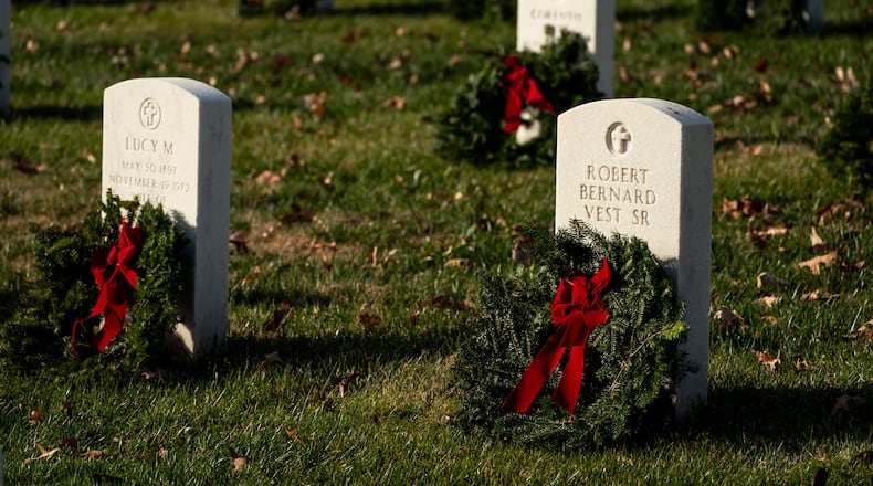Headstones adorned with wreaths are seen at Arlington National Cemetery during Wreaths Across America Day on Saturday, Dec. 16, 2023, in Arlington, Va. (AP Photo/Nathan Howard)