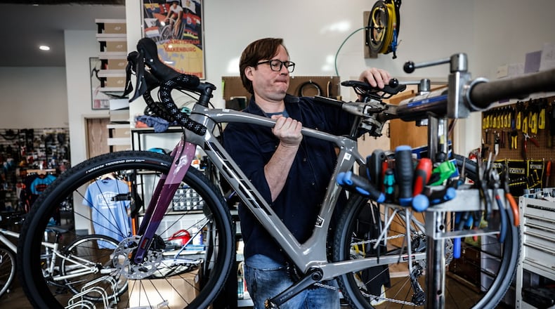 Conrad Dillon, co-owner of Creekside Cyclery works on a bike at their new location on Grange Hall Road in Beavercreek. JIM NOELKER/STAFF