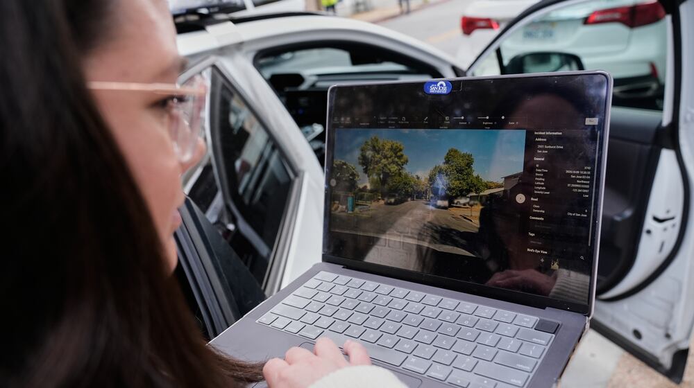 Chelsea Palacio, public information manager for the City of San Jose, showcases how a small detection camera uses AI to detect road hazards and potholes, in San Jose, Calif., Wednesday, Nov. 12, 2025. (AP Photo/Godofredo A. Vásquez)