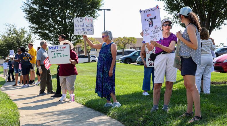 Demonstrators gathered on Thursday on the sidewalk along Presidential Drive in Fairborn near Wright State University in front of a DoubleTree by Hilton that U.S. Rep. Mike Turner (R-Dayton) was scheduled to speak at during a meeting with a defense trade group. Demonstrators were holding signs criticizing Turner for not hosting town halls or public meetings. BRYANT BILLING / STAFF