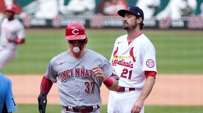 Cincinnati Reds' Tyler Stephenson, left, scores on a wild pitch by St. Louis Cardinals relief pitcher Andrew Miller, right, during the seventh inning of a baseball game Sunday, Sept. 13, 2020, in St. Louis. (AP Photo/Jeff Roberson)