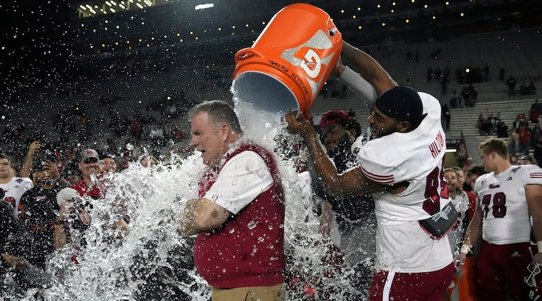 Miami (Ohio) defensive lineman Kobe Hilton, front right, douses head coach Chuck Martin, front left, after they defeated Colorado State in the Arizona Bowl NCAA college football game, Saturday, Dec. 28, 2024, in Tucson, Ariz. (AP Photo/Rick Scuteri)