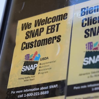 A SNAP EBT information sign is displayed outside of a convenience store in Baltimore, Monday, Nov. 10, 2025. (AP Photo/Stephanie Scarbrough)