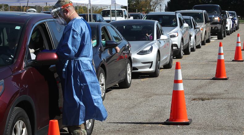 A National Guard member administers a COVID-19 test to a motorist during the Clark County Combined Health District's free COVID-19 testing clinic at Kenton Ridge High School Friday. BILL LACKEY/STAFF