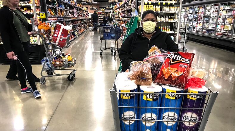 A shopper at the new Kroger Market Place on Alex Bell, waits in line to check out while shopping last month. JIM NOELKER/STAFF