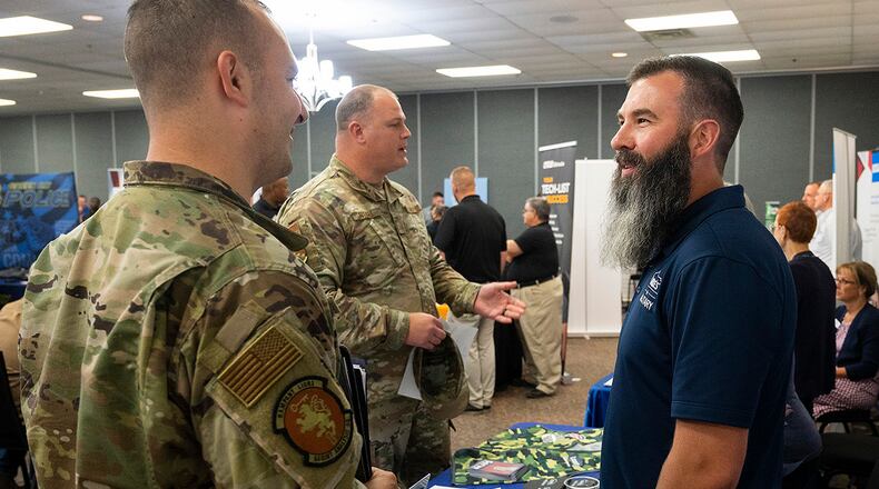 Nick Tefft, representing Lowe’s, talks with one Airman as Master Sgt. Michael Fitzell (background), 88th Medical Group, seeks information from another company official during the Hiring Our Heroes event June 22, 2022 at Hope Hotel near Wright-Patterson Air Force Base. U.S. AIR FORCE PHOTO/R.J. ORIEZ