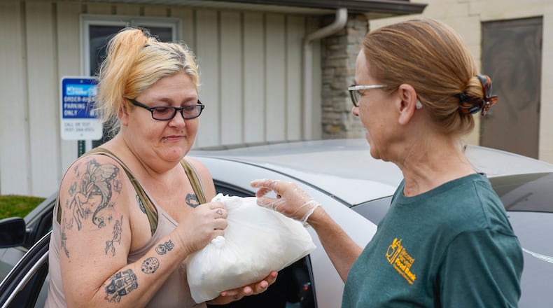 Holly Holland, left, of Springfield, receives groceries from volunteer Carol Conrad as part of OrderAhead, Second Harvest Food Bank's choice program, on Wednesday, July 9, 2025, at Second Harvest Food Bank. JOSEPH COOKE/STAFF