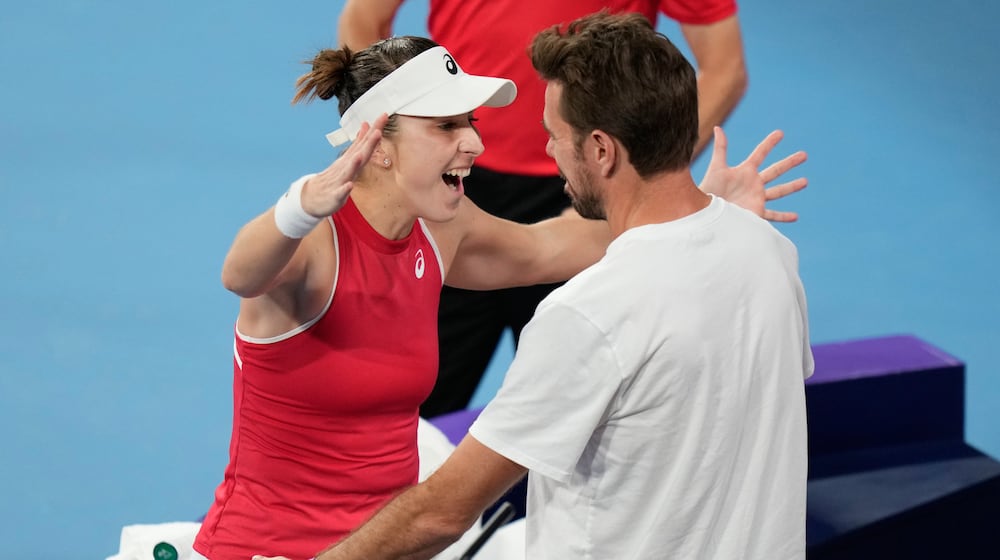 Belinda Bencic of Switzerland, left, celebrates with teammate Stan Wawrinka after defeting Iga Swiatek of Poland in their final match at the United Cup tennis tournament in Sydney, Sunday, Jan. 11, 2026. (AP Photo/Rick Rycroft)