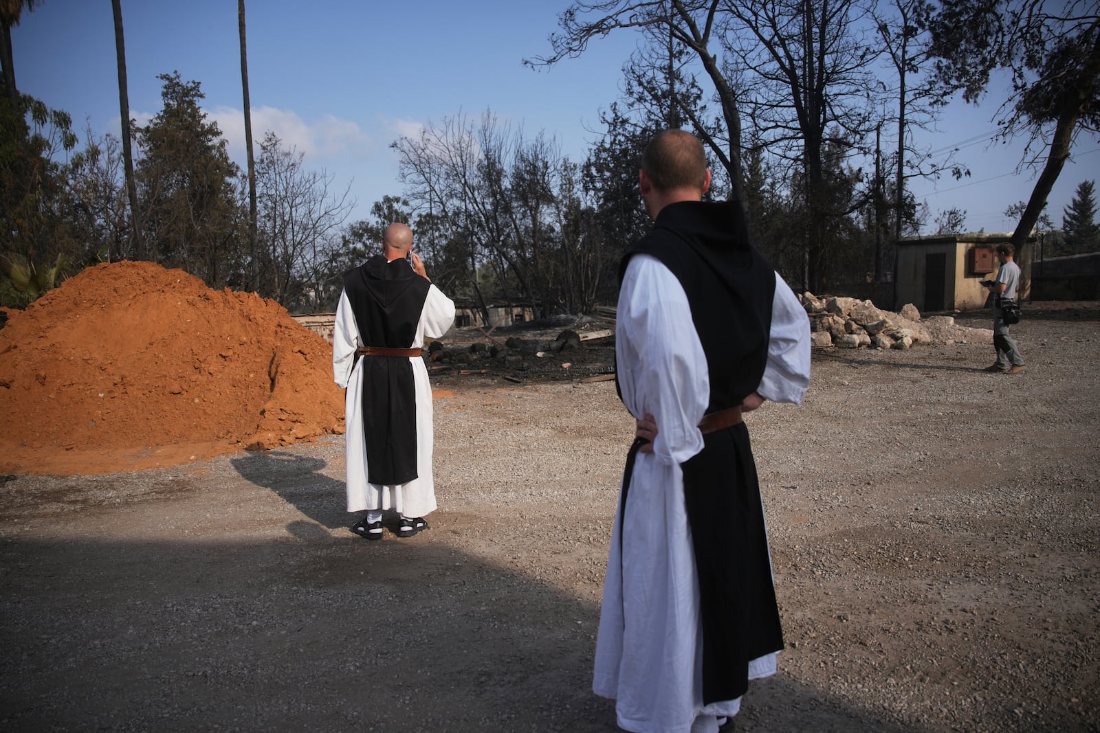 Roman Catholic Trappist monks take in the scene near a wildfire in Latrun, Israel, outside of Jerusalem Thursday, May 1, 2025. (AP Photo/Ohad Zwigenberg)