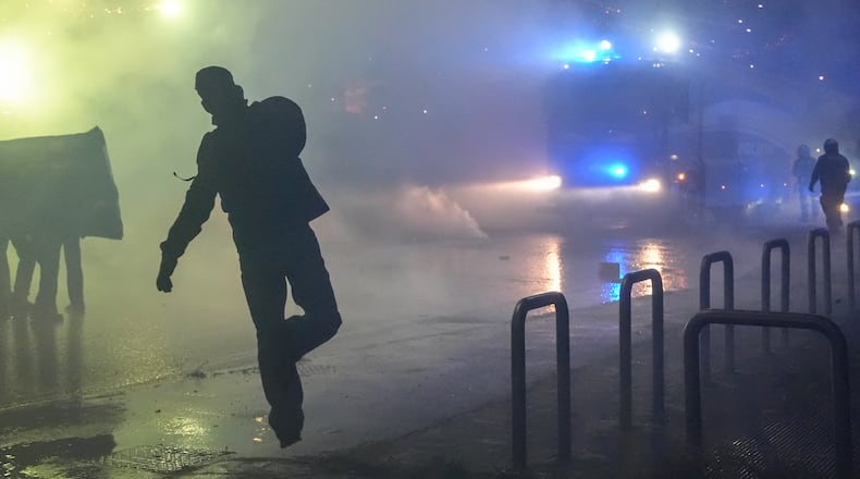 Demonstrators face riot police during a protest against the Milan-Cortina 2026 Olympics, in Milan, Italy, Saturday Feb. 7, 2026. (Claudio Furlan/LaPresse via AP)