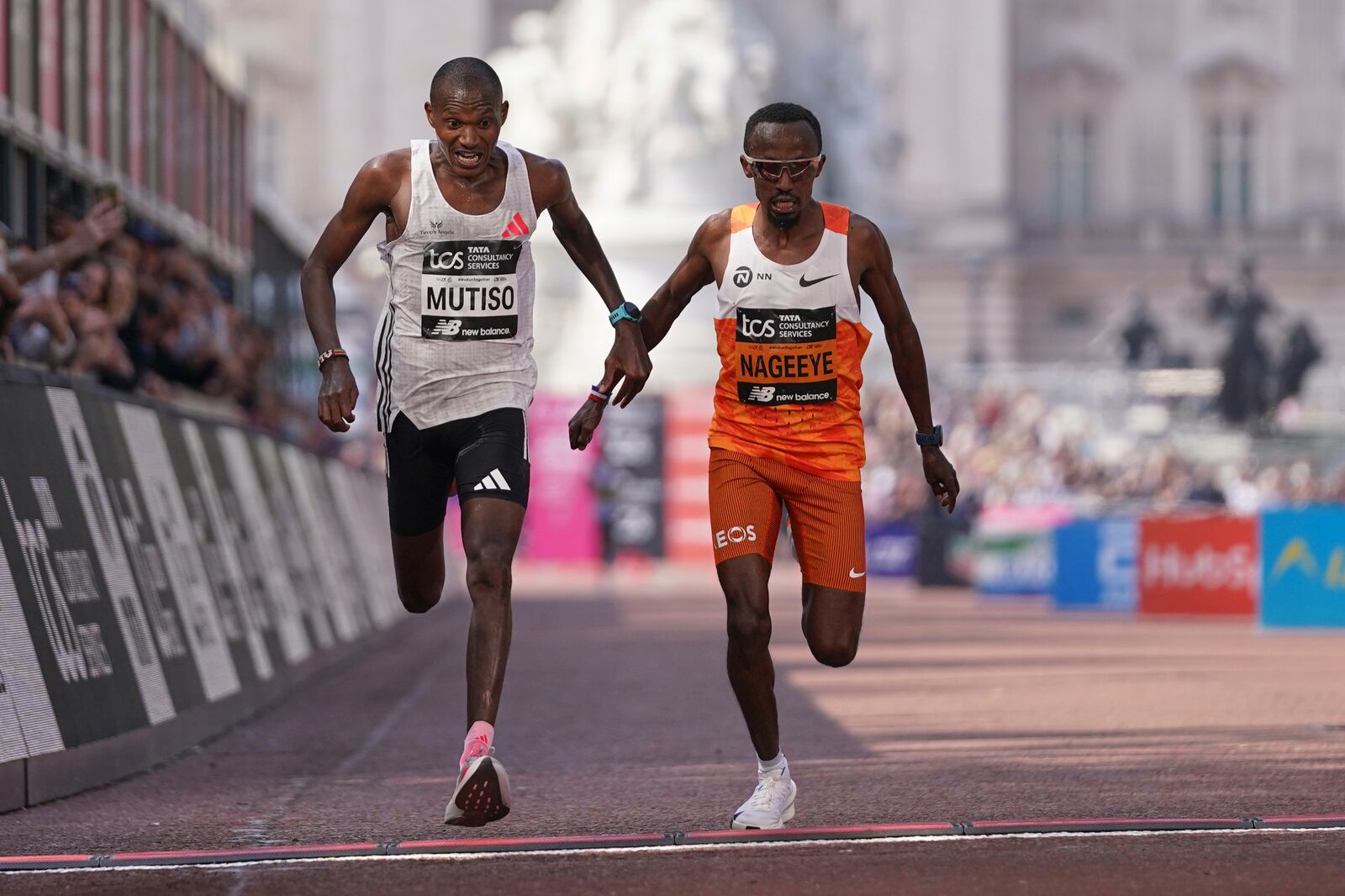 Alexander Mutiso of Kenya, left,crosses the line to place third just ahead of Abdi Nageeye of the Netherlands, at the London Marathon, Sunday, April 27, 2025. (AP Photo/Alberto Pezzali)