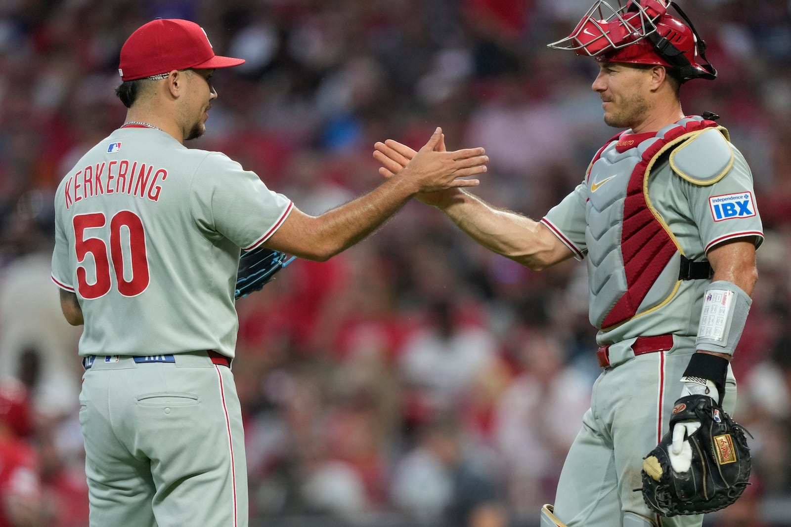 Philadelphia Phillies pitcher Orion Kerkering, left, and catcher J.T. Realmuto celebrate after winning a baseball game against the Cincinnati Reds Monday, Aug. 11, 2025, in Cincinnati. (AP Photo/Carolyn Kaster)