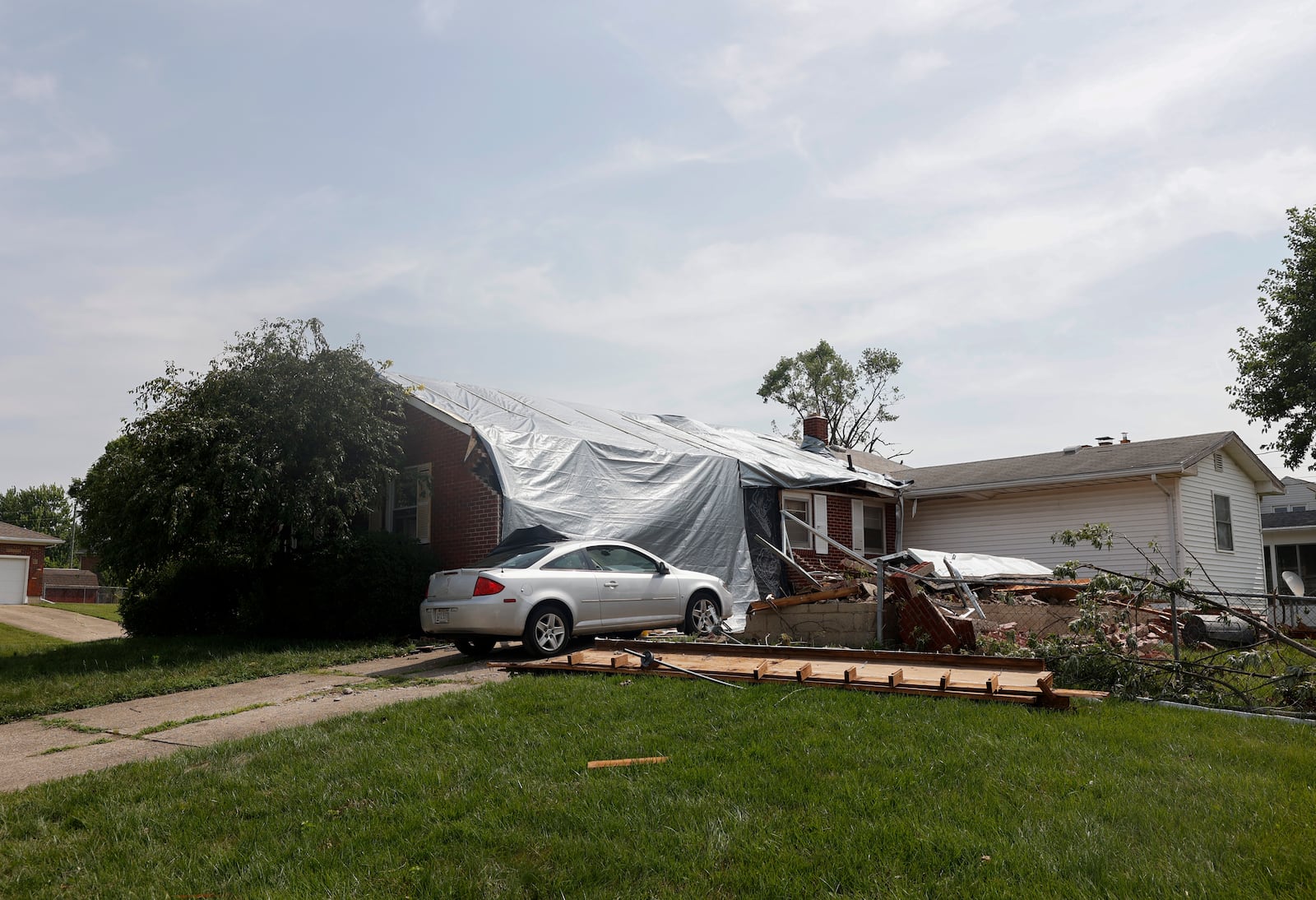 A view of a damaged home, fence and driveway on Monday, July 21, 2025 following a storm that happened over the weekend in Moorefield Township. JOSEPH COOKE/STAFF