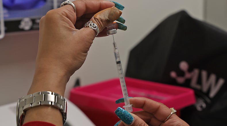 Senika Channels gets a patient's COVID vaccine ready Friday, Feb. 25, 2022 at the Clark County Combined Health District office in the Southern Village Shopping Center. BILL LACKEY/STAFF