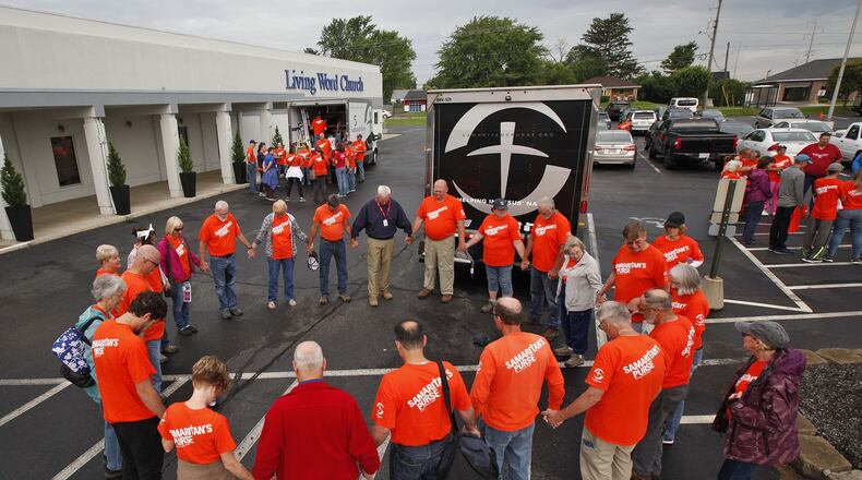 Volunteers with Samaritan’s Purse gather for prayer before going to tornado damaged neighborhoods in the Dayton area to assist homeowners. TY GREENLEES / STAFF