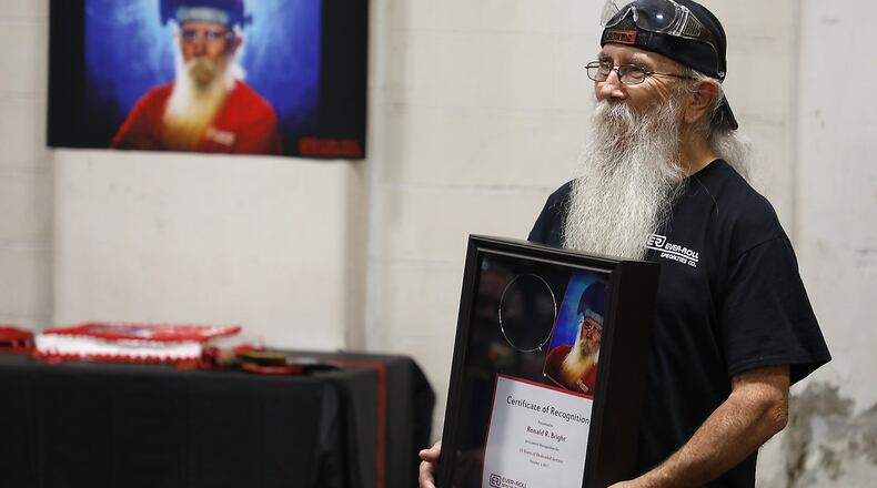 Ron Bright holds the Certificate of Recognition he received Monday at the luncheon in his honor at the Ever-Roll Specialities Company. Ron has worked at the factory in Lawrenceville for 55 years. Bill Lackey/Staff