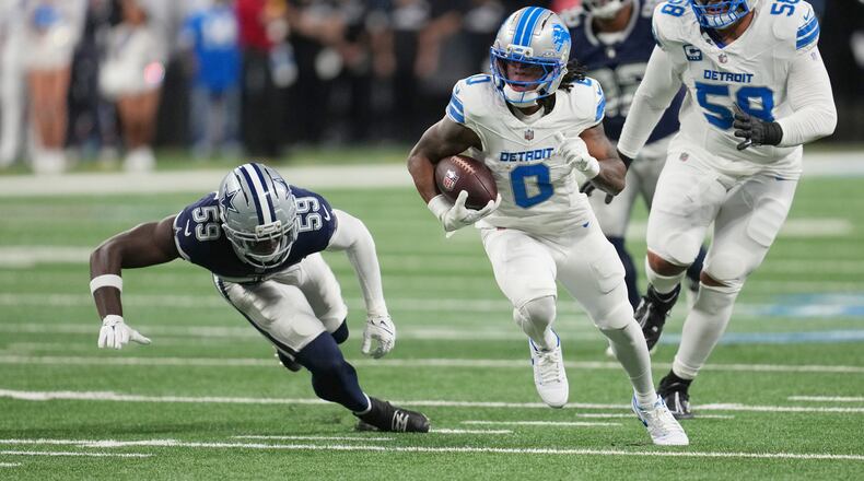 Detroit Lions running back Jahmyr Gibbs (0) runs the ball as Dallas Cowboys linebacker Jr. Kenneth Murray (59) tries to stop him during the first half of an NFL football game Thursday, Dec. 4, 2025, in Detroit. (AP Photo/Paul Sancya)