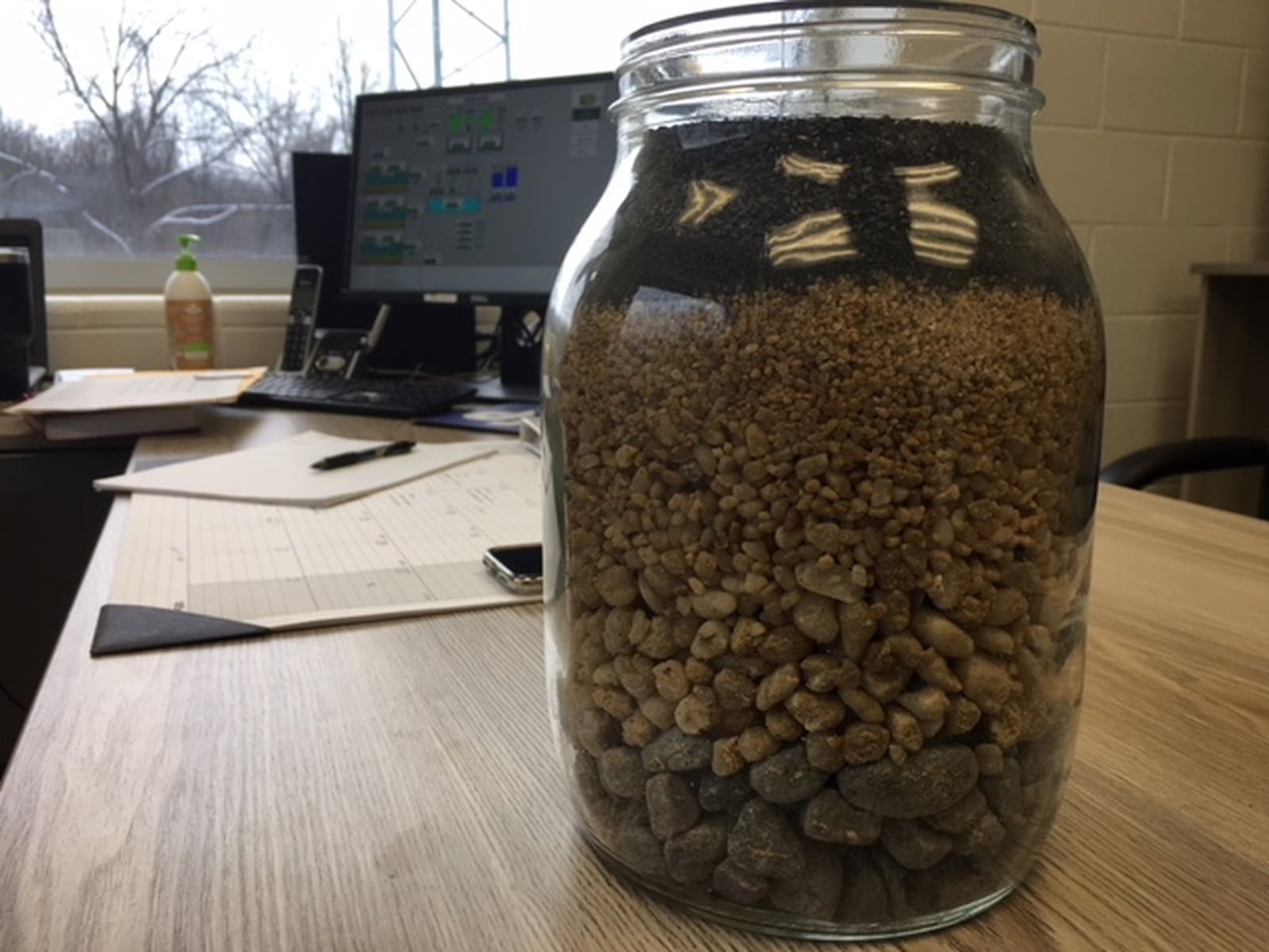A jar shows a cross section of the material used in the large filters at Yellow Springs new water plant. Richard Wilson/Staff