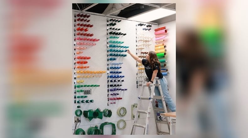 Liberty Bloemhard, shop manager at Bolder Outfitters and Company, grabs threads for a new job. Bolder Outfitters, located at 240 Patrick Ave. in Urbana, recently held a ribbon cutting earlier this month. Contributed