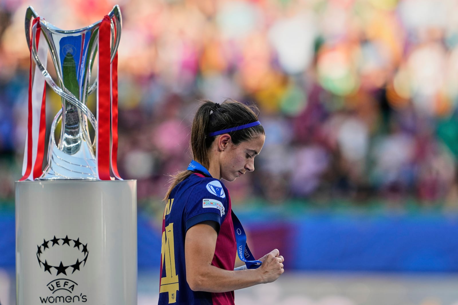 Barcelona's Aitana Bonmati walks past the winner trophy during the podium ceremony after Arsenal won the women's Champions League final soccer match between Arsenal and FC Barcelona at the Jose Alvalade stadium in Lisbon, Saturday, May 24, 2025. (AP Photo/Armando Franca)