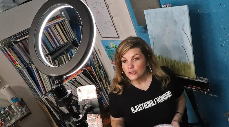 Tracey Tackett, owner of Sip & Dipity Paint Bar, teaches a paint class online using her cell phone Wednesday while her business is closed due to the stay-at-home order. BILL LACKEY/STAFF