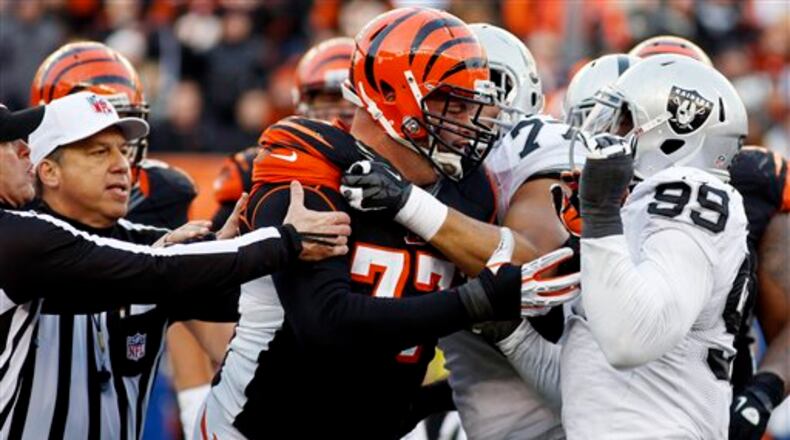 Cincinnati Bengals tackle Andrew Whitworth (77) fights with Oakland Raiders defensive end Lamarr Houston (99) in the second half of an NFL football game, Sunday, Nov. 25, 2012, in Cincinnati. Both players were ejected from the game. The Bengals won 34-10. (AP Photo/David Kohl)