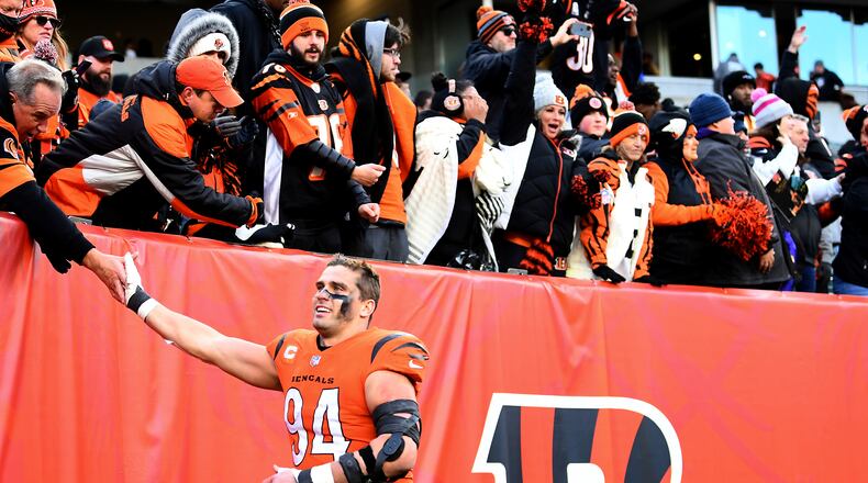 FILE - Cincinnati Bengals defensive end Sam Hubbard (94) high-fives fans after the team's NFL football game against the Pittsburgh Steelers on Nov. 28, 2021, in Cincinnati. Hubbard grew up in Cincinnati and followed the “Bungles” as they stumbled and bumbled throughout much of his youth. His first three years as a Bengals were pretty much the same. “It’s just really cool how many people have thanked me for the relief they’ve felt, the time that they had watching the games, the great memories they’ve had from these wins this year,” Hubbard said. (AP Photo/Emilee Chinn, File)