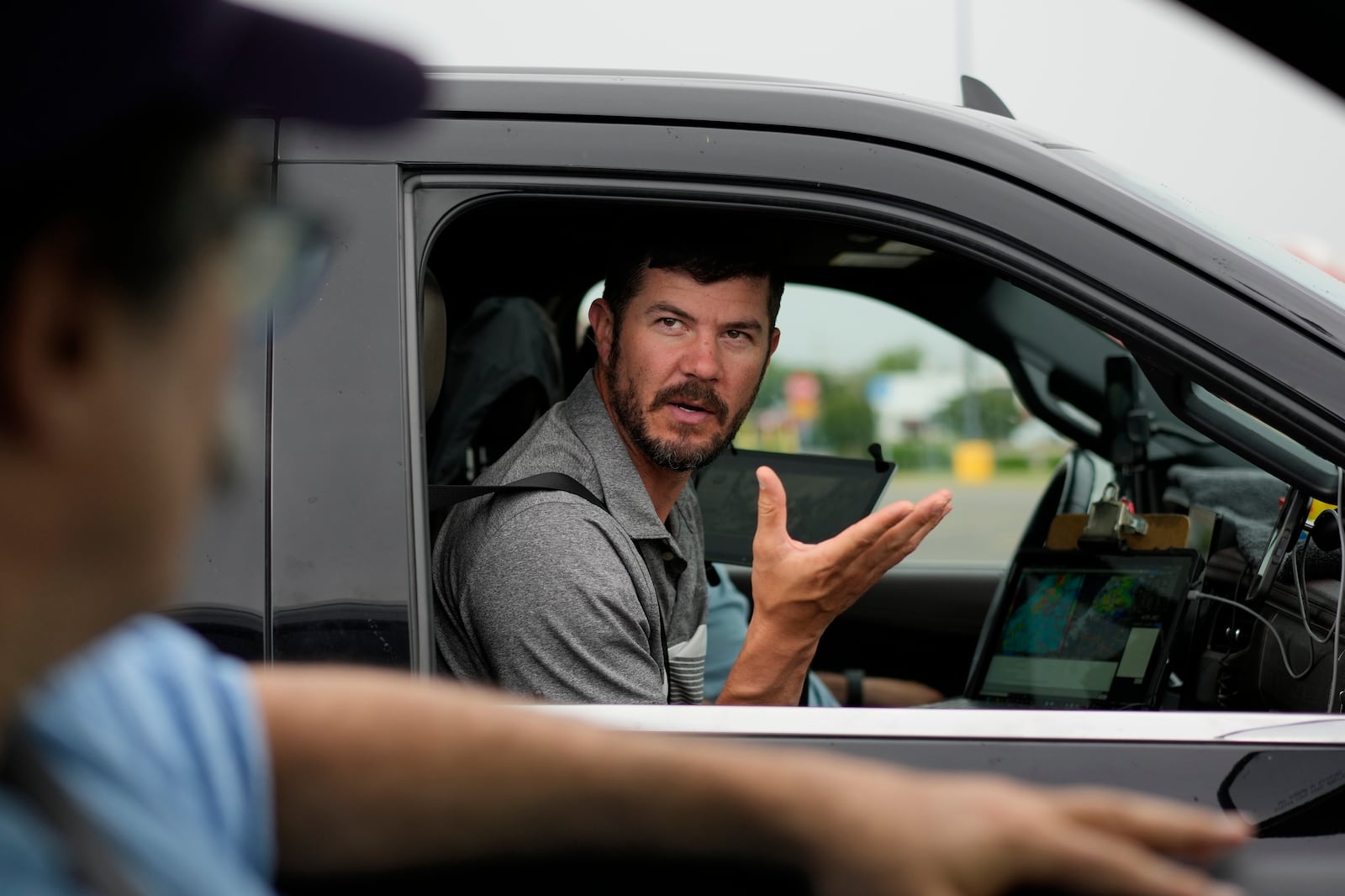 Victor Gensini, Northern Illinois University meteorology professor and a lead scientist of Project ICECHIP, speaks with Seth Borenstein, Associated Press science writer, as they stage in a Walmart parking lot before a Project ICECHIP operation Tuesday, June 3, 2025, in Atlus, Okla. (AP Photo/Carolyn Kaster)