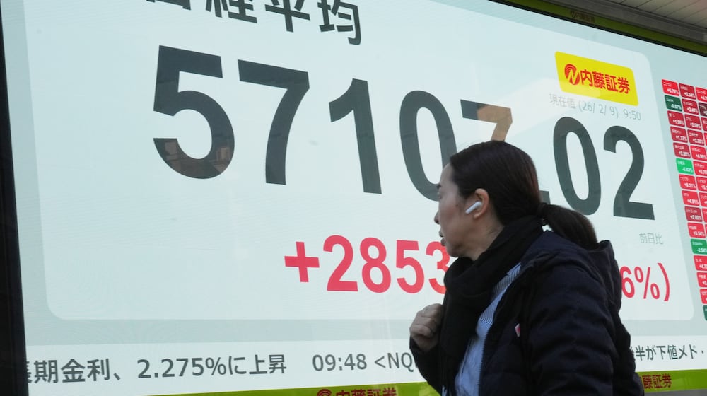A person walks in front of an electronic stock board showing Japan's Nikkei index at a securities firm Monday, Feb. 9, 2026, in Tokyo. (AP Photo/Eugene Hoshiko)
