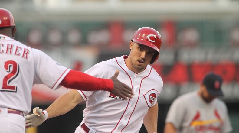 The Reds’ Adam Duvall slaps hands with third-base coach Billy Hatcher after a three-run home run against the Cardinals on Tuesday, June 7, 2016, at Great American Ball Park in Cincinnati. David Jablonski/Staff
