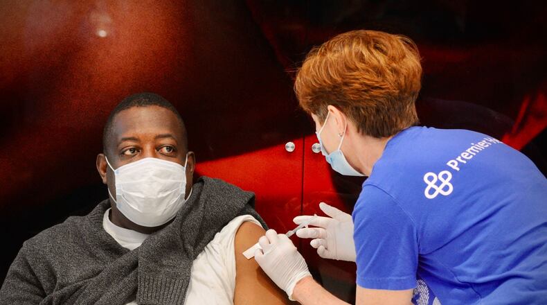 Premier Health administered its 100,000th dose of the COVID-19 vaccine to Tom Long during a clinic at the University of Dayton Arena on Monday, April 12, 2021. MARSHALL GORBY\STAFF