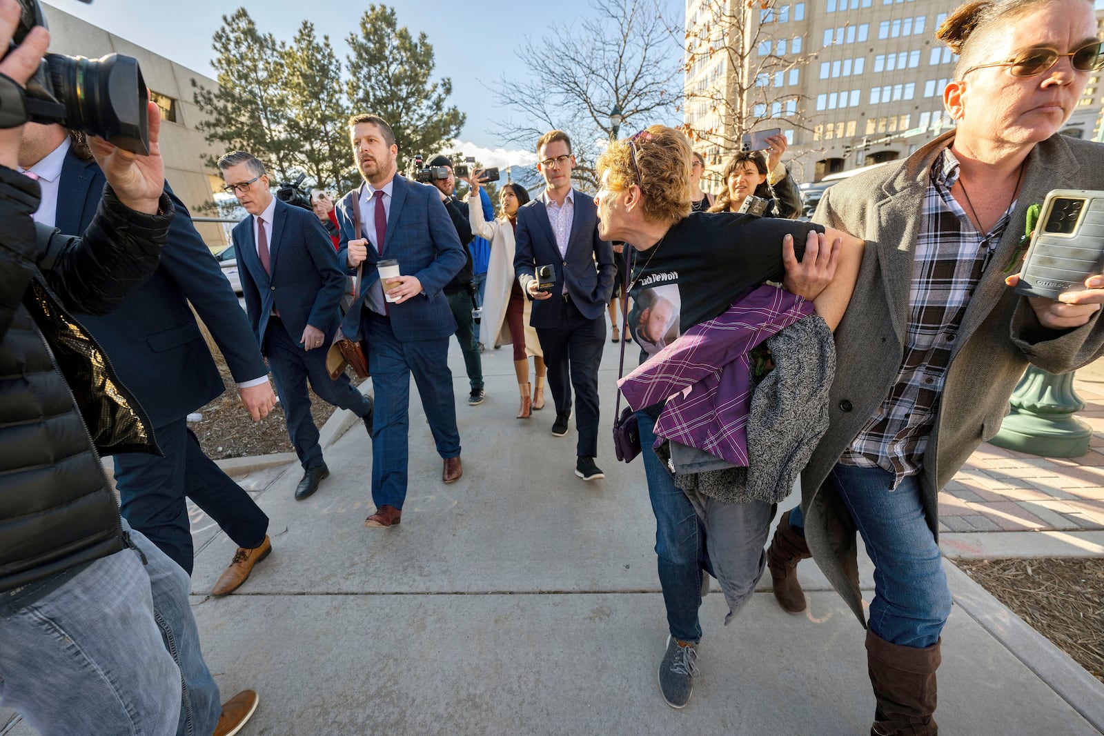 FILE - Chrystina Page, right, holds back Heather De Wolf, as she yells at Jon Hallford, left, the owner of Back to Nature Funeral Home, as he leaves with his lawyers following a preliminary hearing, Thursday, Feb. 8, 2024, outside the El Paso County Judicial Building in Colorado Springs, Colo. (Christian Murdock/The Gazette via AP, File)