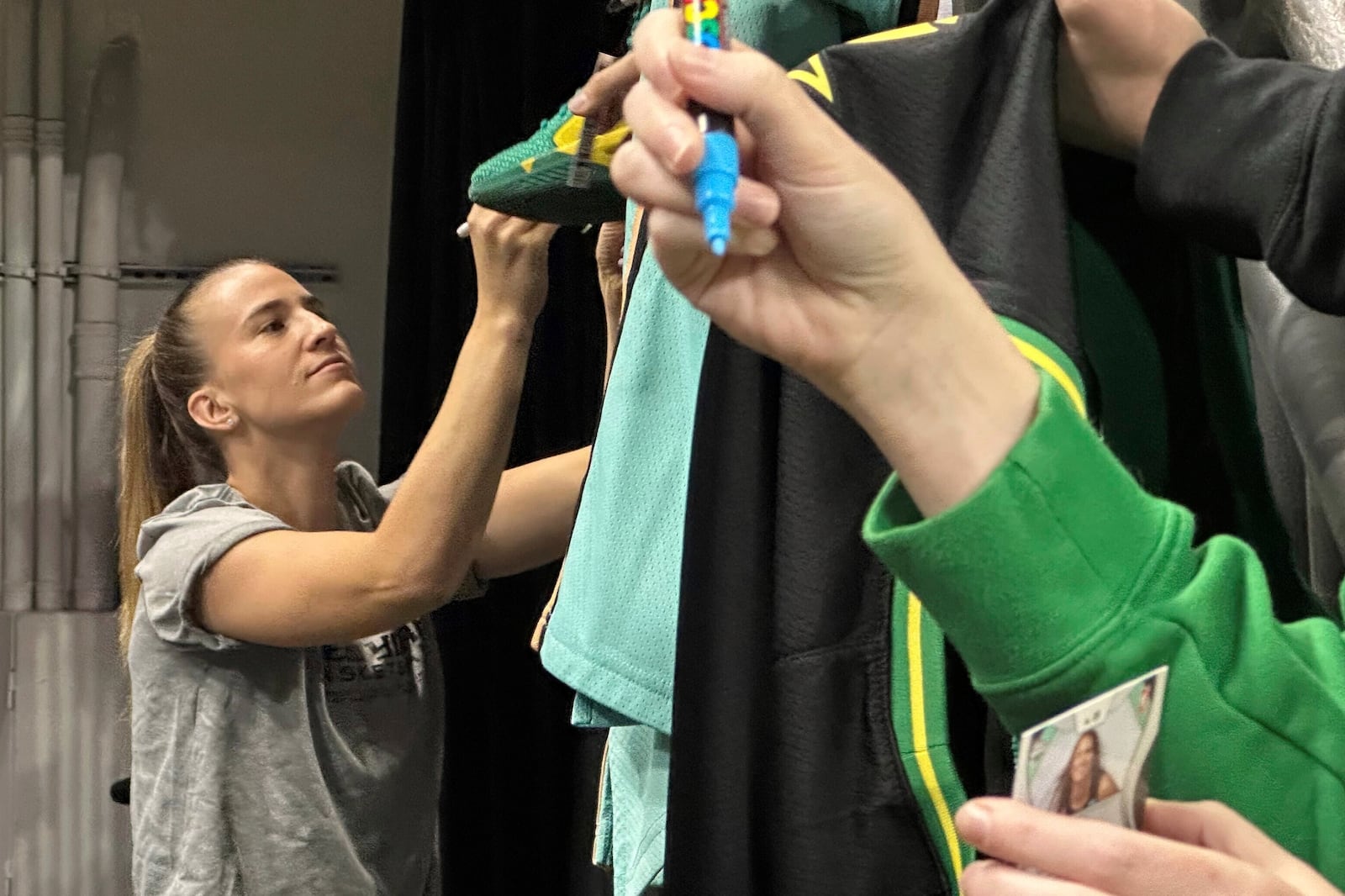 New York Liberty guard Sabrina Ionescu, left, gives autographs before a preseason WNBA basketball game against the Toyota Antelopes, of Japan, in Eugene, Oregon, Monday, May 12, 2025. (AP Photo/Anne M. Peterson).