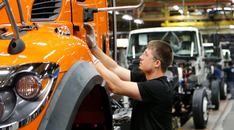 A worker at Navistar assembles a truck cab. Bill Lackey/Staff