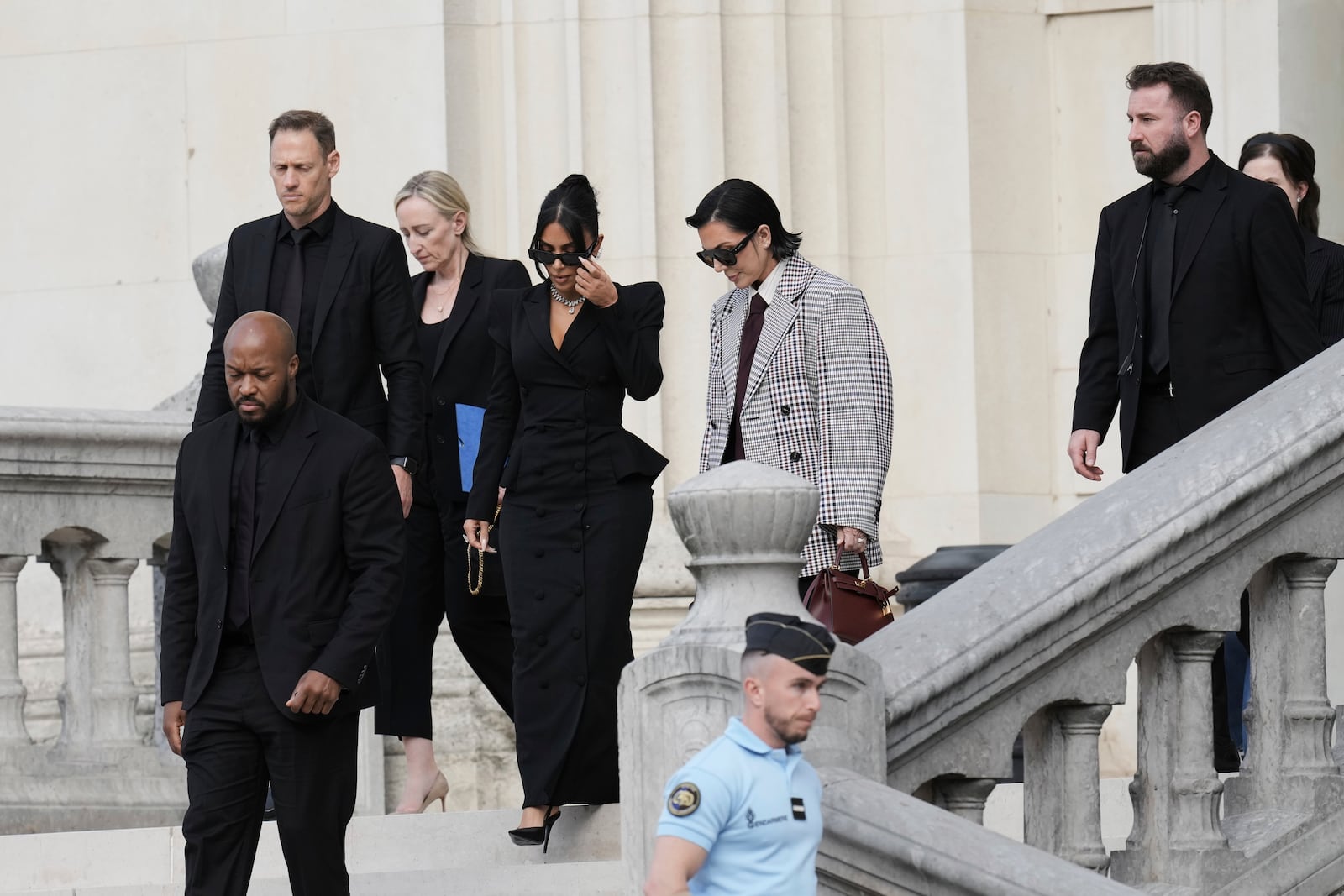 Kim Kardashian, center left, accompanied by her mother Kris Jenner, center right, leaves the justice palace after testifying, regarding a robbery of millions of dollars in jewels from her Paris hotel room in 2016, in Paris, Tuesday, May 13, 2025. (AP Photo/Aurelien Morissard)