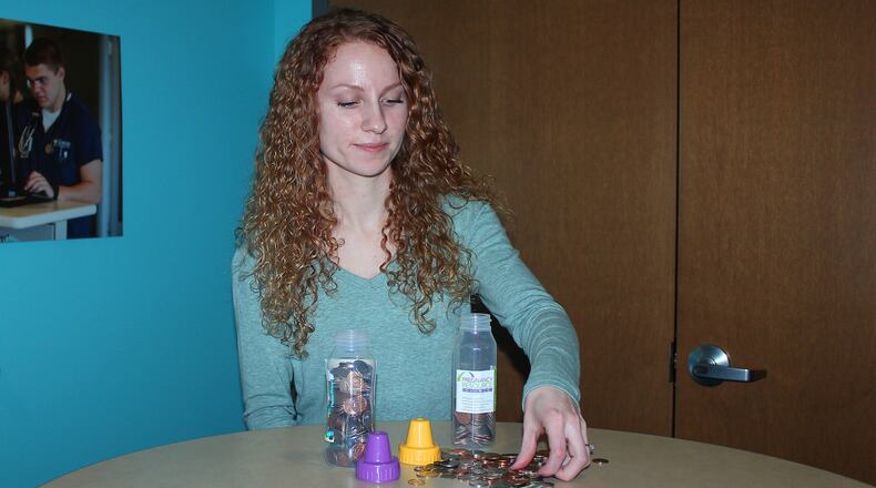 Cedarville University student Stephanie Limbers puts loose change in baby bottles to help raise money for the Pregnancy Resource Center of Clark County. JEFF GUERINI/STAFF