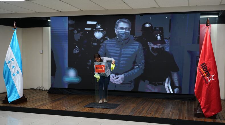 A screen displays an image of former Honduran President Juan Orlando Hernandez, a day after President Donald Trump said he plans to pardon Hernandez for a 2024 drug trafficking sentence, before the start of a press conference of Ruling party presidential candidate Rixi Moncada in Tegucigalpa, Honduras, Saturday, Nov. 29, 2025. (AP Photo/Moises Castillo)