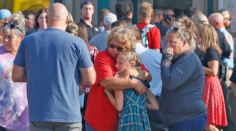 Family members are reunited with their children at the German Twp. Government Center following a Northwestern School District bus crash on State Route 41 Tuesday, August 22, 2023. One student died, and dozens were injured on the bus that had 52 students and the driver aboard. BILL LACKEY/STAFF