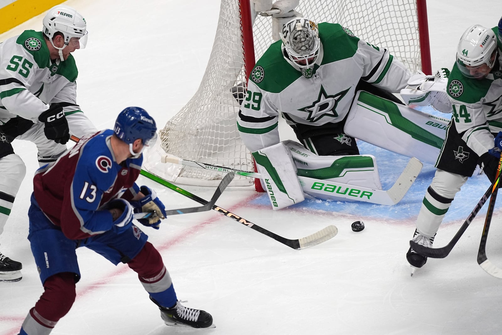 Colorado Avalanche right wing Valeri Nichushkin (13) shoots the puck past Dallas Stars defenseman Thomas Harley (55) as Stars goaltender Jake Oettinger (29) covers the net in the first period of Game 6 of an NHL hockey first-round playoff series Thursday, May 1, 2025, in Denver. (AP Photo/David Zalubowski)