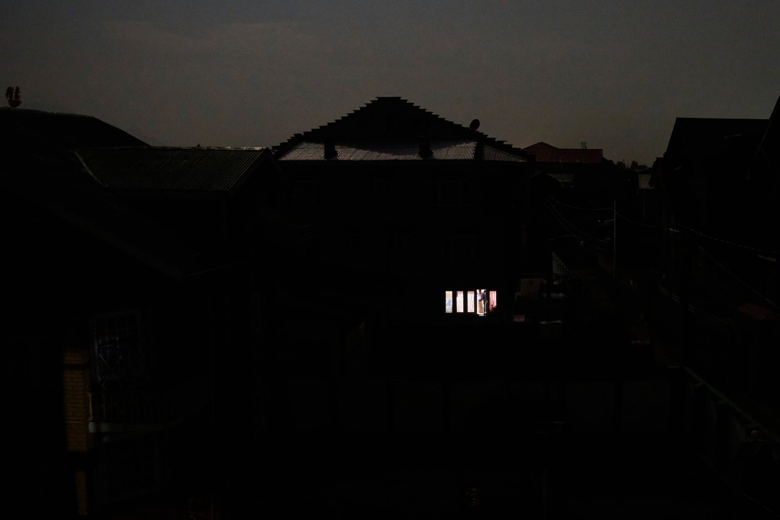 A Kashmiri man looks out from the window of his house during blackout after the residents of the Srinagar reported hearing explosions in Srinagar, Indian controlled Kashmir, Saturday, May 10, 2025.(AP Photo/Dar Yasin)