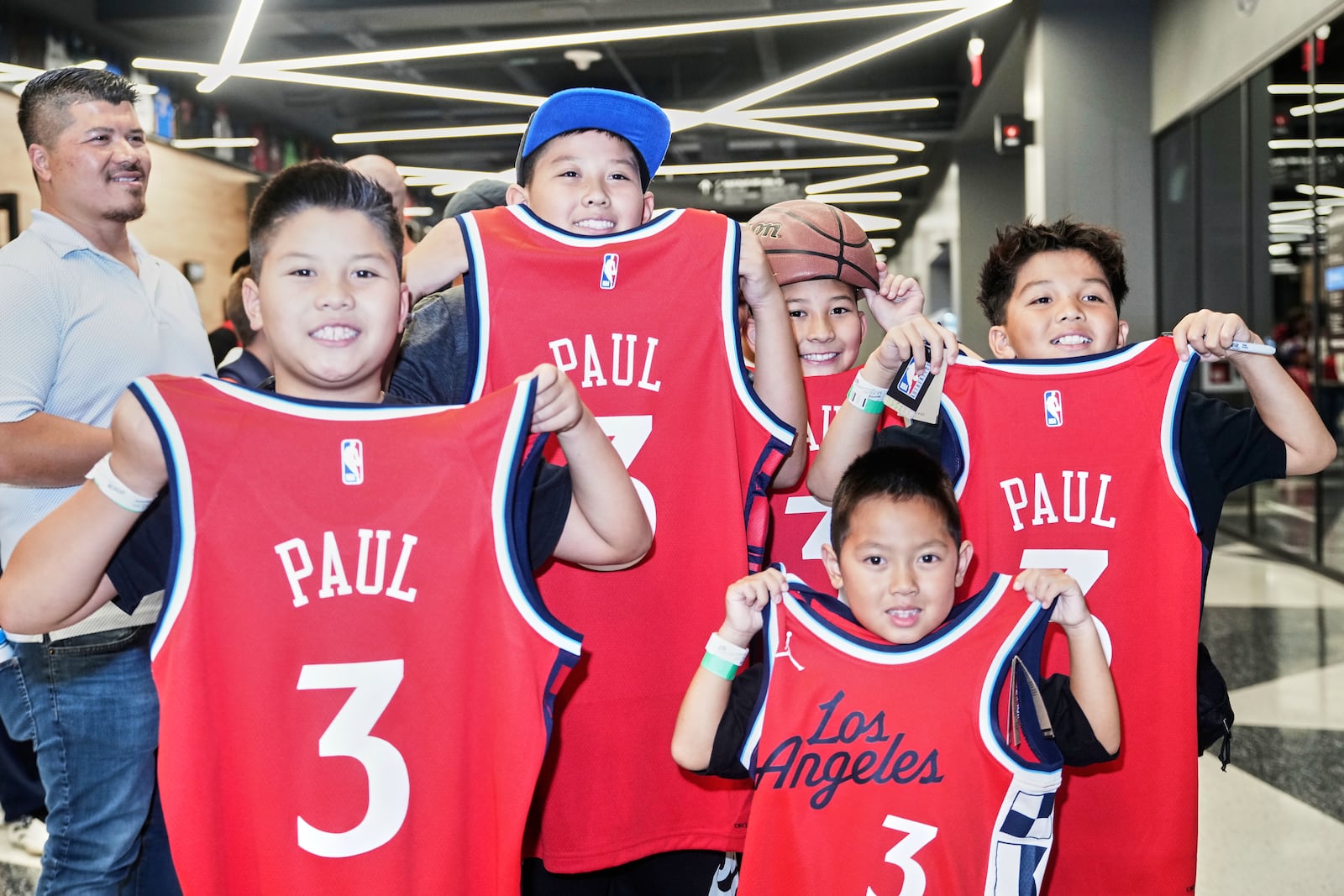 Members of the Dong family from Fountain Valley, Calif., wait in line to have their jerseys autographed by Chris Paul after being introduced as the newest member of the Los Angeles Clippers during a basketball news conference at Intuit Dome in Inglewood, Calif., Monday, July 28, 2025. (AP Photo/Damian Dovarganes)