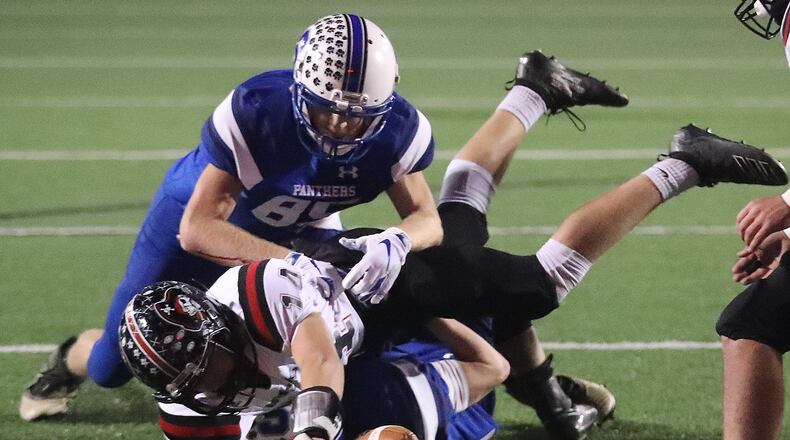 Covington’s Deacon Shields tries to stretch into the end zone as he’s tackled by two Chillicothe Southeastern players near the goal line. BILL LACKEY/STAFF