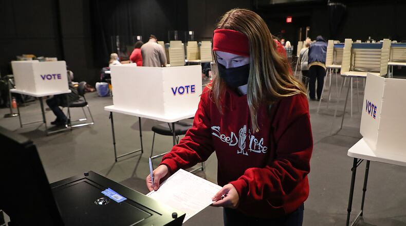 Clark County resident Grace Storck slides her ballot into the voting machine after casting her vote for the very first time Saturday at the Clark State Performing Arts Center. Grace said she's a student at Wilmington College and didn't think she could get back on Tuesday for election day. BILL LACKEY/STAFF