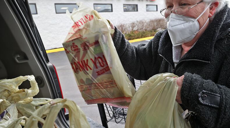 Becky Backus loads groceries into the back of her car at Groceryland on South Limestone Street in February. Backus said at the time that her grocery bill increased by $150 per month. BILL LACKEY/STAFF