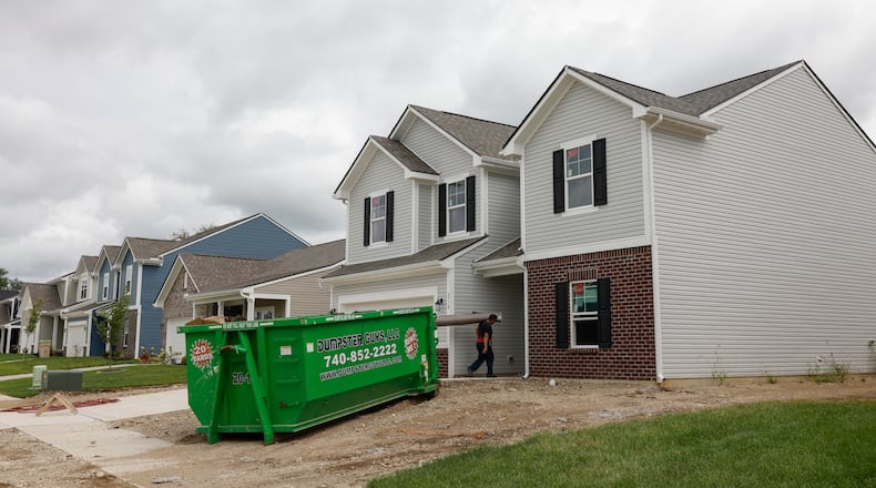 A construction worker carries a rug into a home in the Melody Parks neighborhood on Wednesday, Aug. 20, 2025, in Springfield. JOSEPH COOKE/STAFF