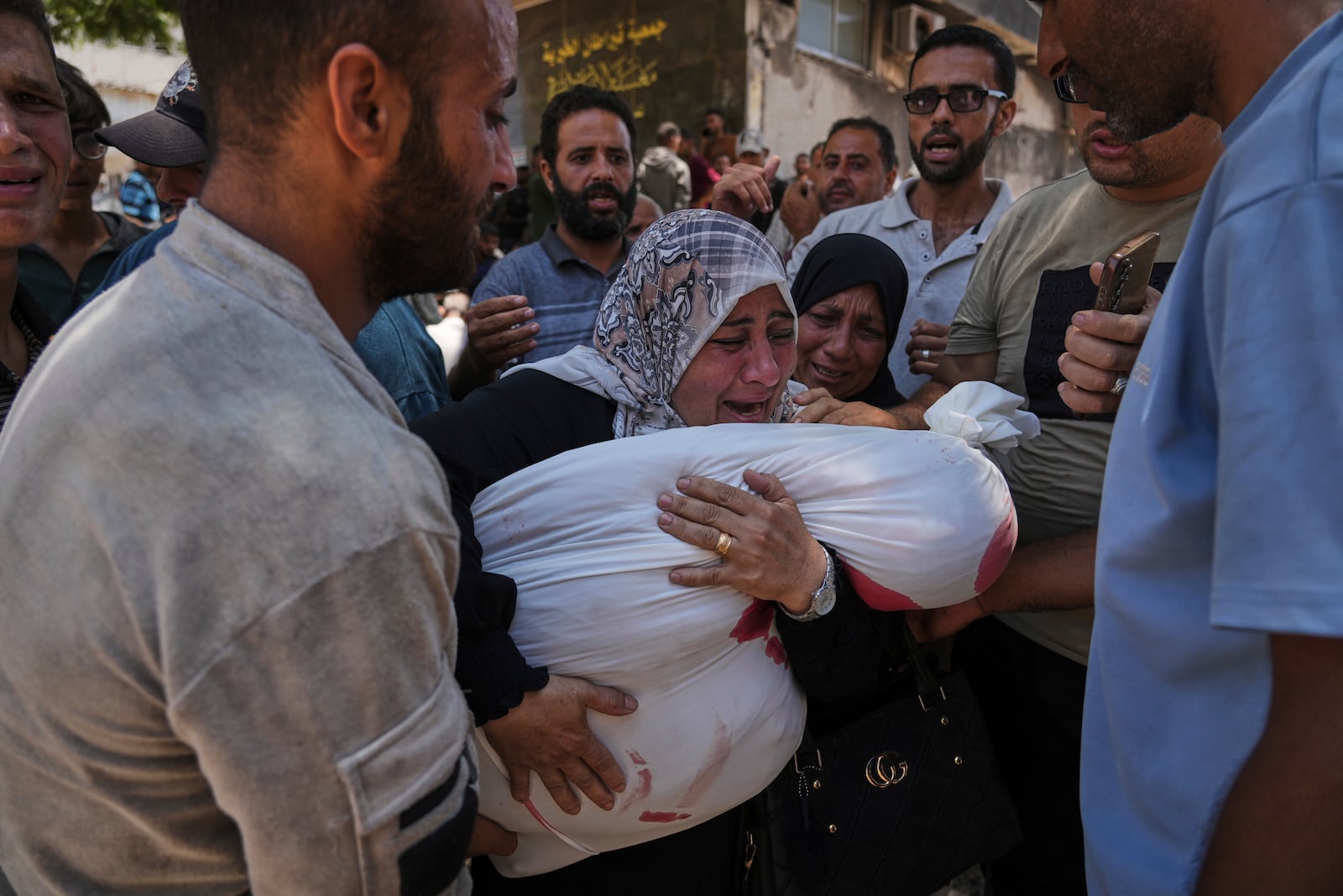 Palestinians mourn their relatives who were killed while trying to reach aid trucks entering northern Gaza through the Zikim crossing with Israel, at Shifa Hospital in Gaza City on Sunday, July 20, 2025. (AP Photo/Jehad Alshrafi)