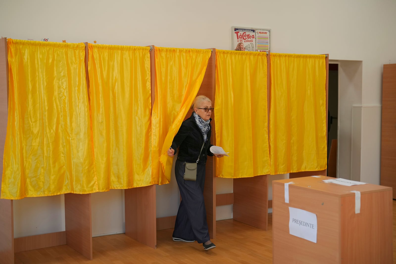 A woman exits after casting her vote in the first round of the presidential election redo in Bucharest, Romania, Sunday, May 4, 2025. (AP Photo/Vadim Ghirda)